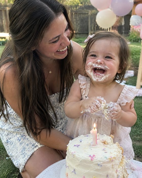 Polaroid of a mother and her laughing one-year-old with frosting on her face at a first birthday — the photo behind the sample song 'One Sweet Mess'